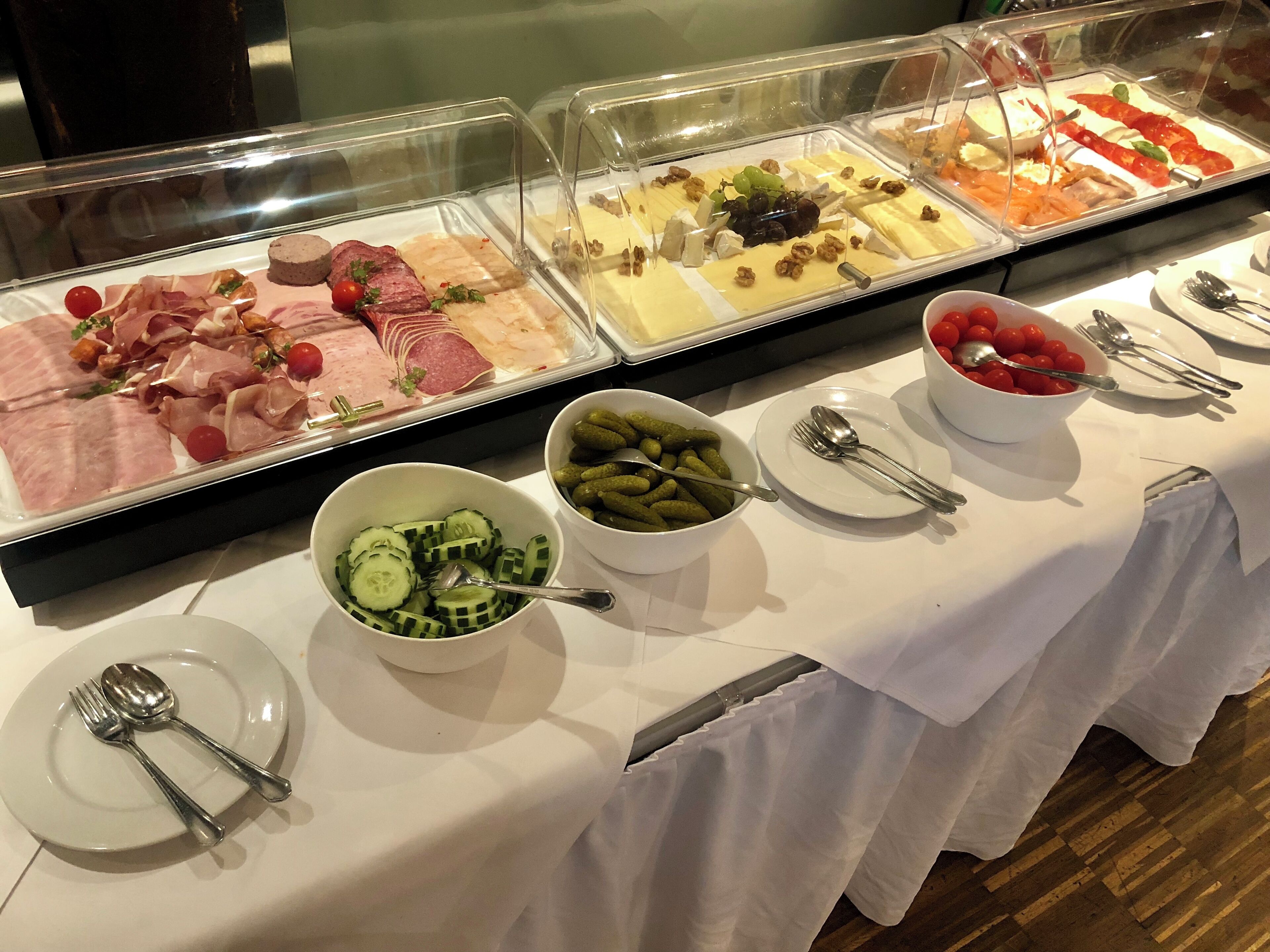 A buffet with various food options including meats, cheeses, and vegetables.