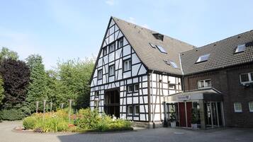 A traditional half-timbered building with a modern entrance and a landscaped garden area.