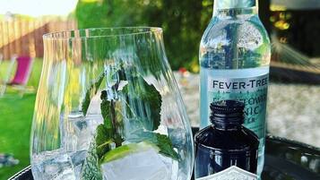 A glass with ice and mint leaves, a bottle labeled "Fever Tree Lower Nic," and a bottle labeled "Hendrick's Gin."