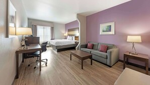 Een hotelkamer met een bed, een bureau, een bank en een klein tafeltje.