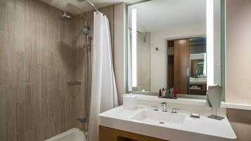 A modern bathroom with a shower, a large mirror, and a vanity with a sink and towel rack.