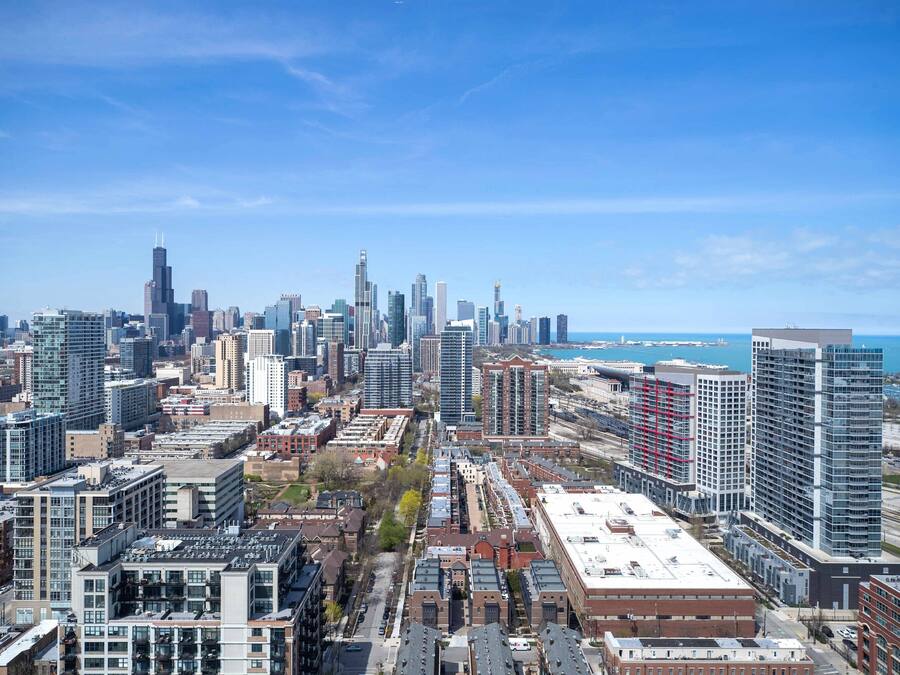 A cityscape with high-rise buildings, a river, and a clear sky.