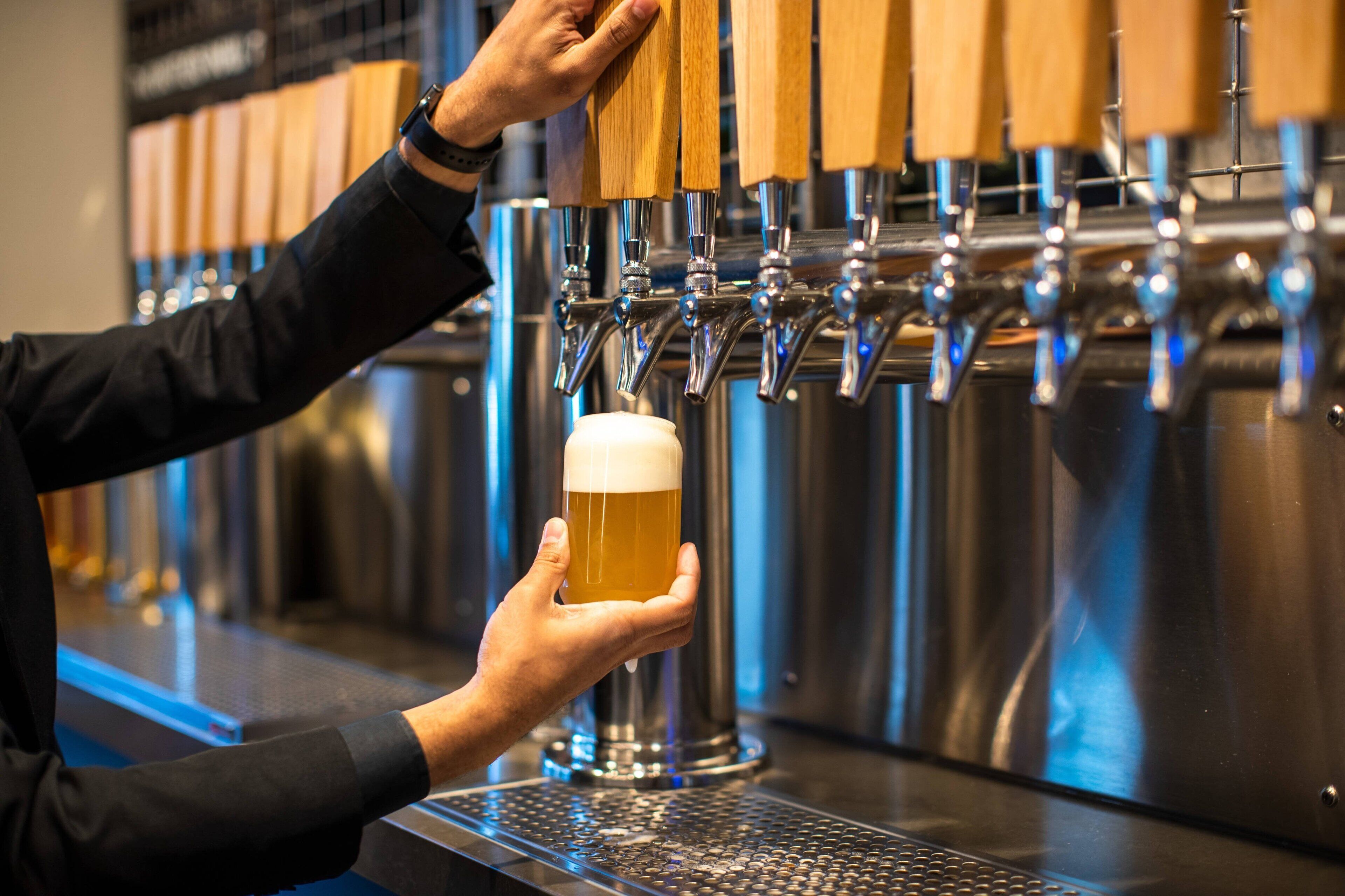 A person pouring beer from a tap.