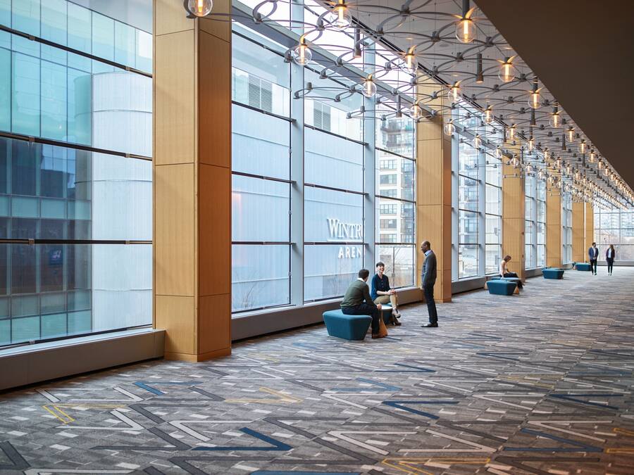 A spacious indoor area with large windows, modern lighting, and seating arrangements.