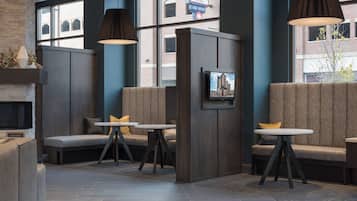 Un intérieur moderne avec des coins salon, des tables et une cheminée.