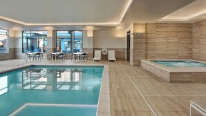 A modern indoor swimming pool with clear water, surrounded by wooden flooring and white furniture. - Residence Inn by Marriott Boise Downtown City Center (Boise)