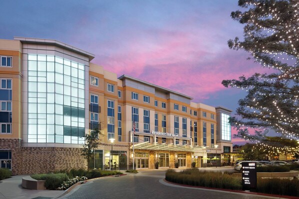A hotel with a modern facade, large windows, and a covered entrance.