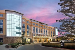 A hotel with a modern facade, large windows, and a covered entrance.