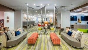 Un espace de vie moderne comprenant un ensemble de canapés, une table basse et un tapis à motifs.