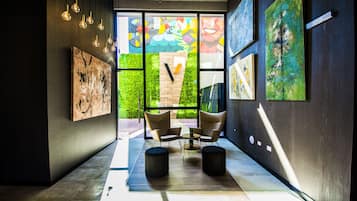 Un interior moderno con una zona de estar, obras de arte en las paredes y vistas amplias a través de grandes ventanales.