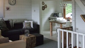 Ein gemütliches Wohnzimmer mit einer Couch, einem Couchtisch und einem Essbereich mit Tisch und Stühlen.
