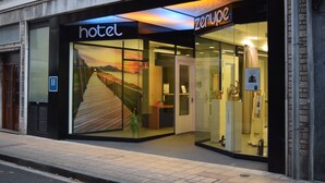 A hotel with a glass facade, a visible reception desk, and a sign indicating a handicap accessible entrance. - Hotel Zerupe (Zarautz)