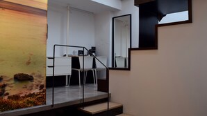 A modern interior with a staircase, a desk, and a large mirror. - Hotel Zerupe (Zarautz)