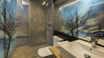 Un baño moderno con ducha, inodoro y lavamanos.