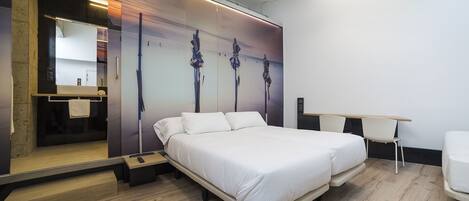Una habitación de hotel moderna con una cama grande, un escritorio y un espejo.