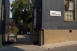 Un edificio con un letrero que dice "203 Münnich" y una entrada protegida por una reja.