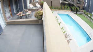 A rooftop terrace with a pool, outdoor seating, and a view of the surrounding buildings. - Lofts Magnolio Cerro Alegre (Valparaiso)