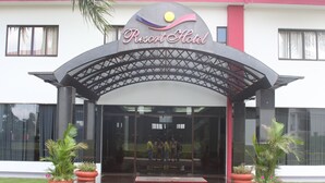 The entrance of a hotel with a modern design, featuring a large archway and potted plants. - Hotel & Resort CIDE (Minga Guazú)
