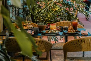 Una mesa puesta con platos de comida, vasos y una bebida.