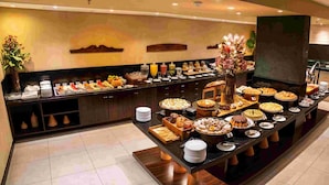 A buffet setup with various food items and beverages. - Hotel Luzeiros Recife (Recife)