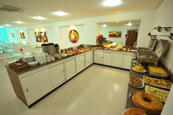 Una mesa de buffet con diferentes alimentos y un pastel grande.