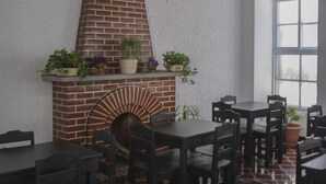 Un restaurante con paredes de ladrillo, chimenea y mesas al aire libre.