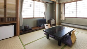 A traditional Japanese room with tatami flooring, a low table, a television, and a safe. - Toya Gokirakutei (Toyako)