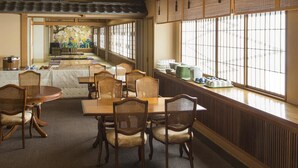 A traditional Japanese-style dining room with tatami mats, low tables, and wooden chairs. - Toya Gokirakutei (Toyako)