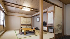 A traditional Japanese room with tatami flooring, a low wooden table, and sliding doors. - Toya Gokirakutei (Toyako)