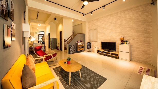 A modern living room with a yellow sofa, a red chair, a wooden coffee table, a TV, and a ceiling fan. - Green Field & Sunshine (Luodong)