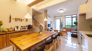 Eine moderne Küche mit Holzarbeitsplatten, einem großen Esstisch aus Holz und eingebauten Geräten.