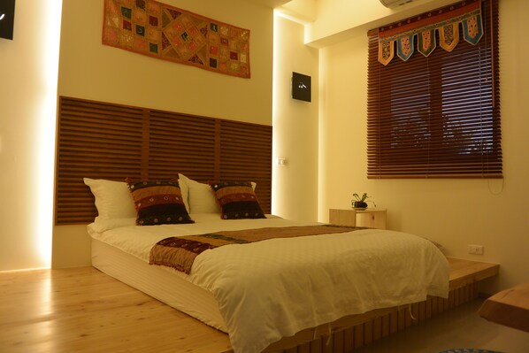 A bedroom with a wooden headboard, a quilted wall hanging, a clock, and a window with blinds. - Songtian B&B (Jiaoxi)