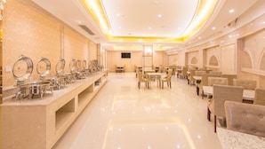 A hotel lobby with a long buffet line, multiple dining tables, and chairs. - Royal International Hotel Disneyland and Wild Animal Park Branch (Shanghai)