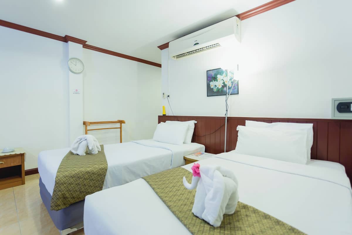 A hotel room with two beds, a clock on the wall, an air conditioning unit, and a painting.