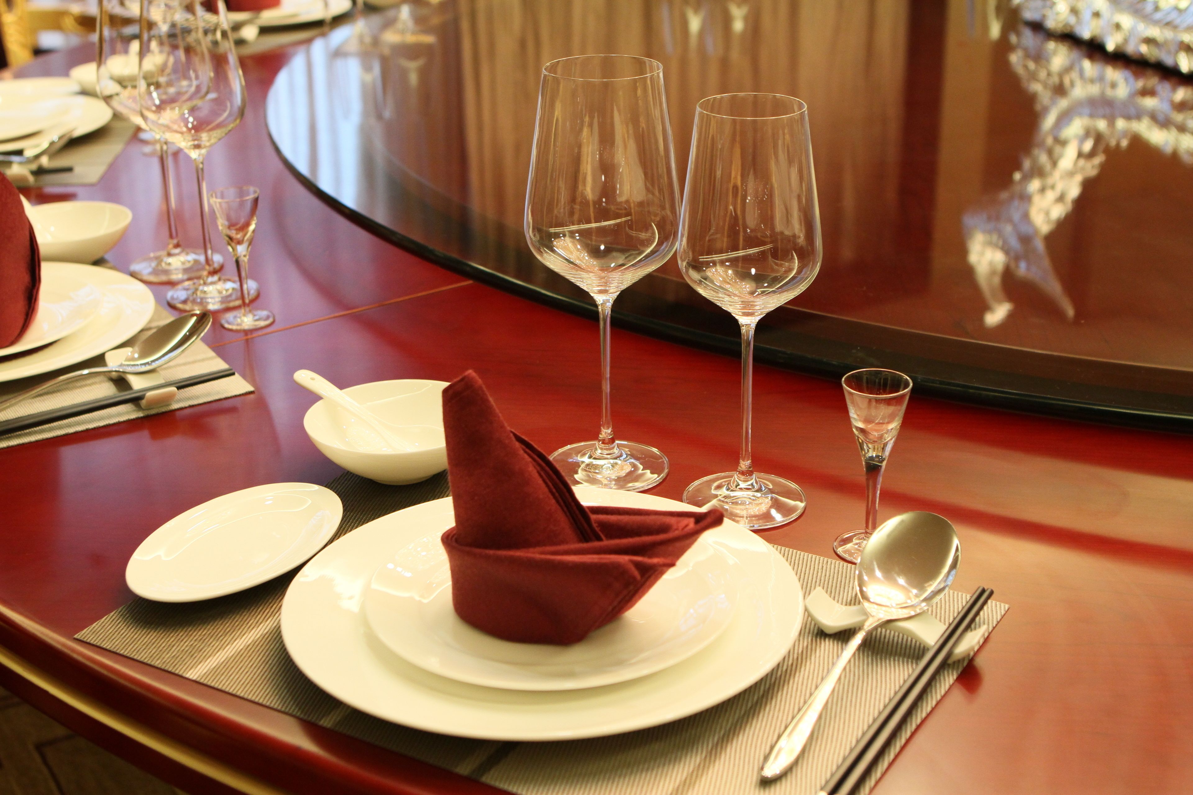 Een net gedekte tafel met borden, glazen en bestek, wat wijst op een formele dineropstelling.