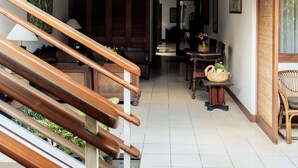 Una escalera que conduce a una sala de estar con techo de madera, una mesa de comedor y sillas.