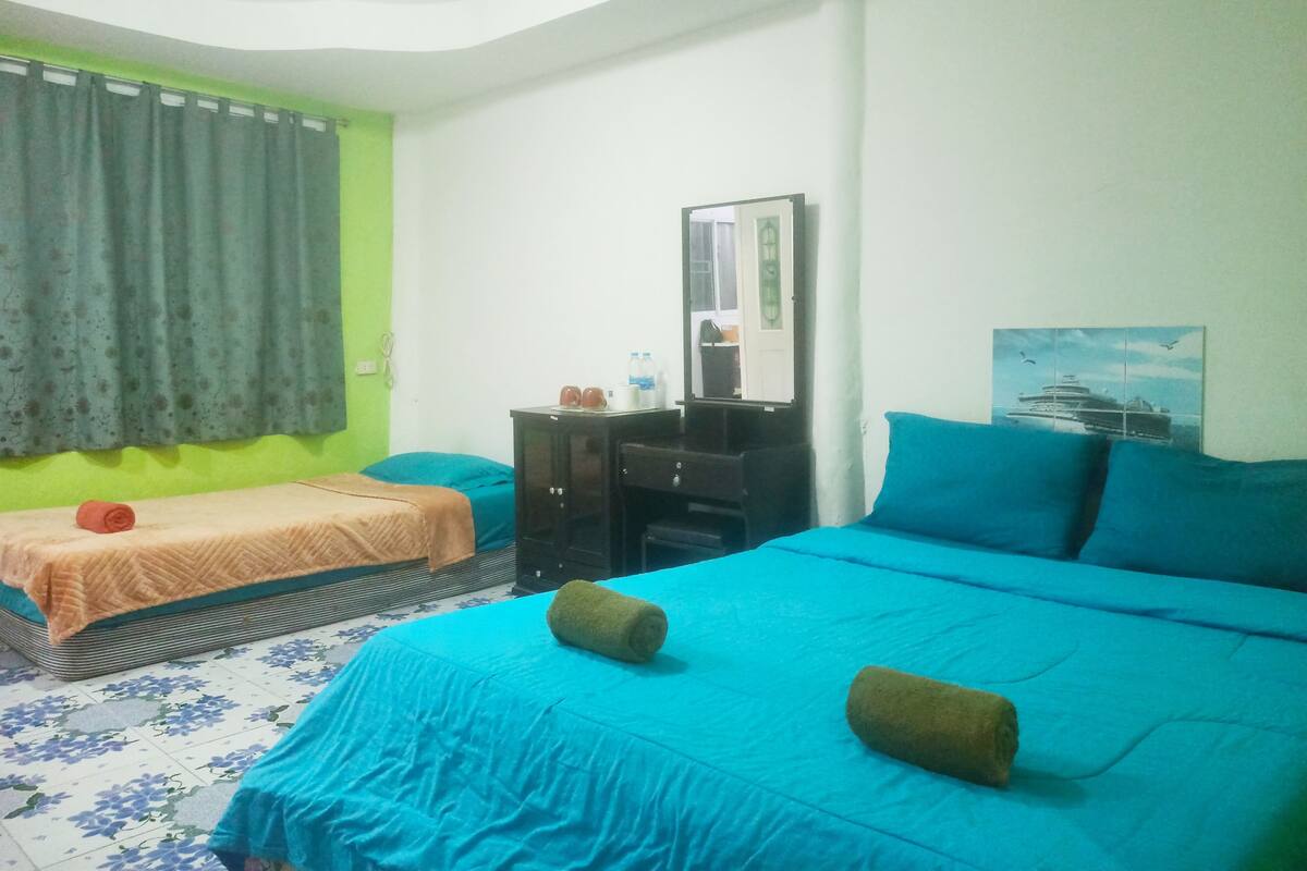 Une chambre d’hôtel avec un lit, une commode, un miroir et un tableau au mur.
