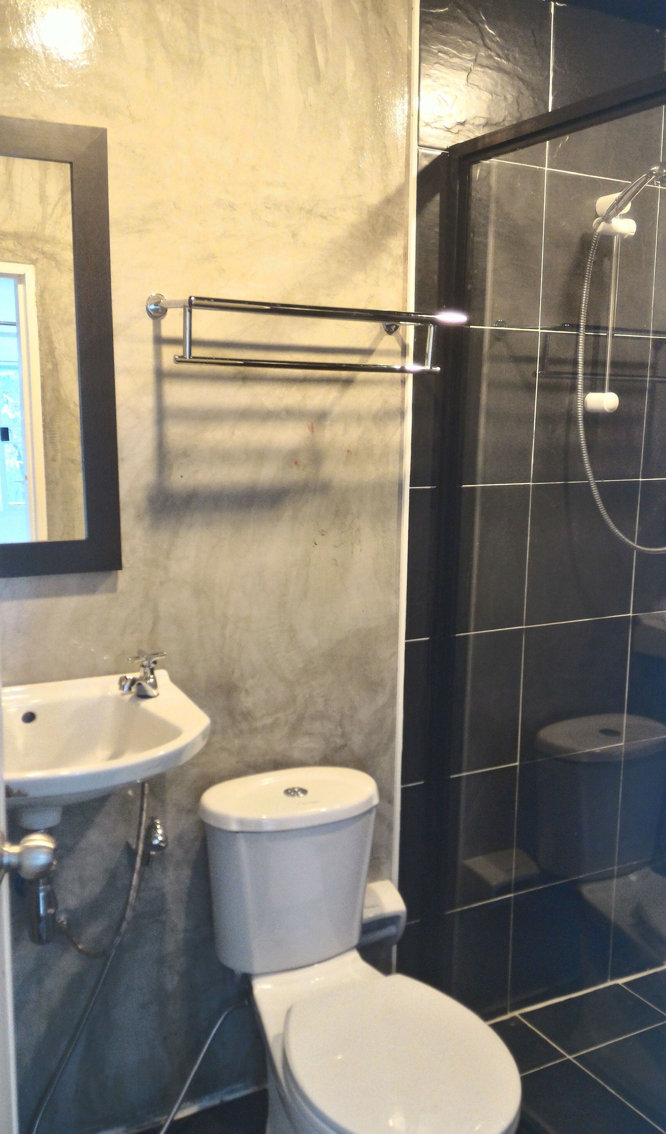 A bathroom with a sink, toilet, and a glass-enclosed shower area.