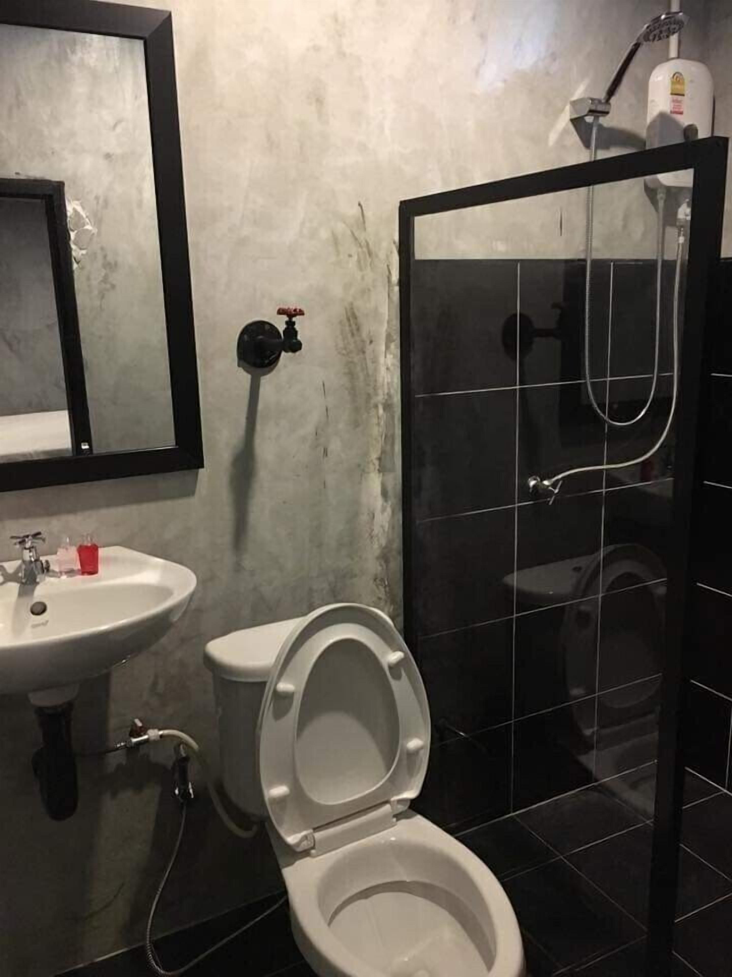 Un baño con lavamanos blanco, inodoro y zona de ducha.