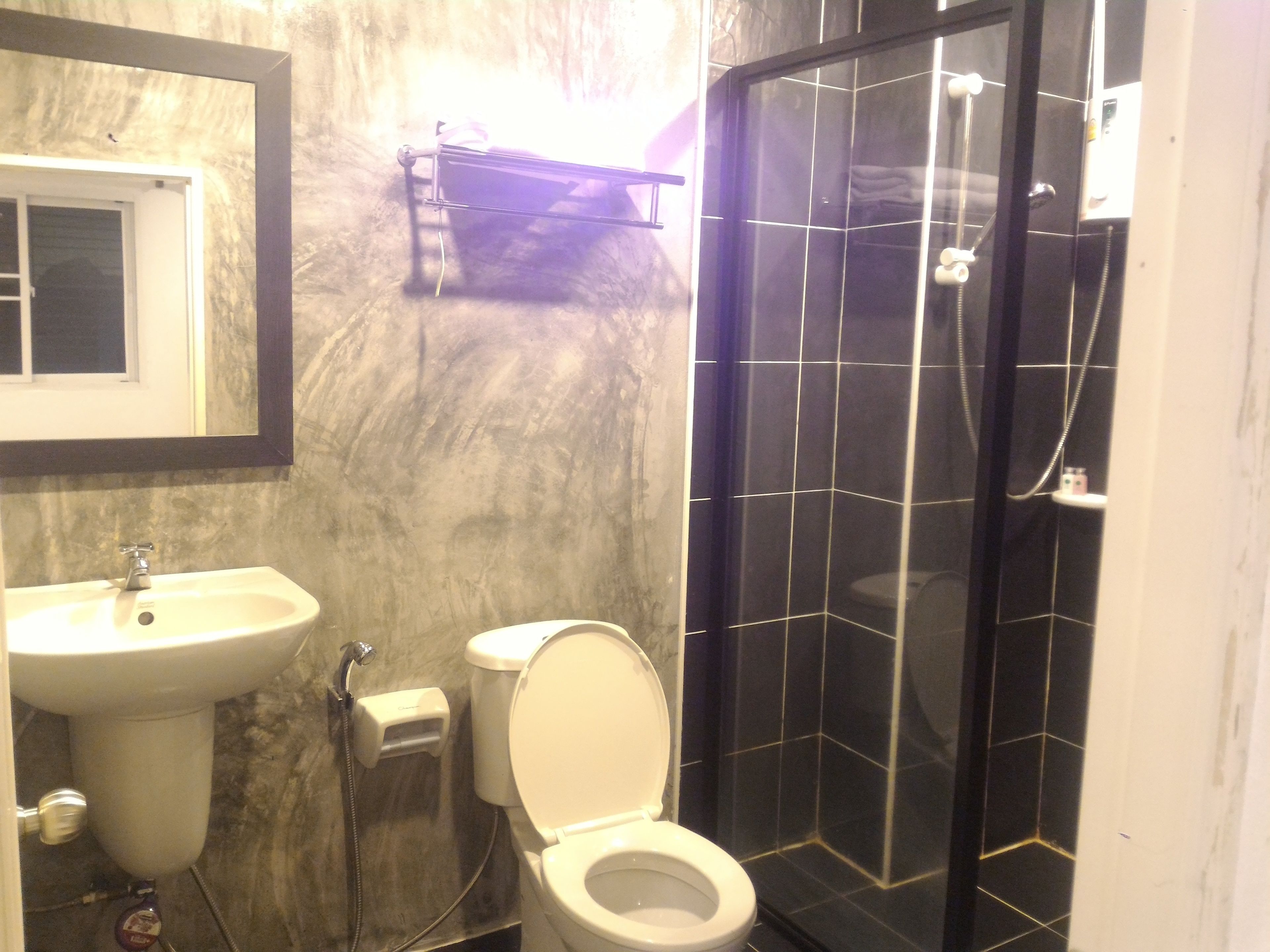 A bathroom with a sink, toilet, and a glass-enclosed shower area.