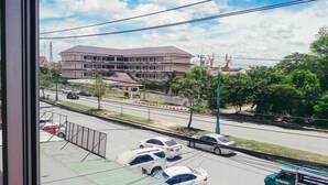 A view of a building with multiple floors and a parking lot with several cars. - Muster House - Hostel (Ayutthaya)