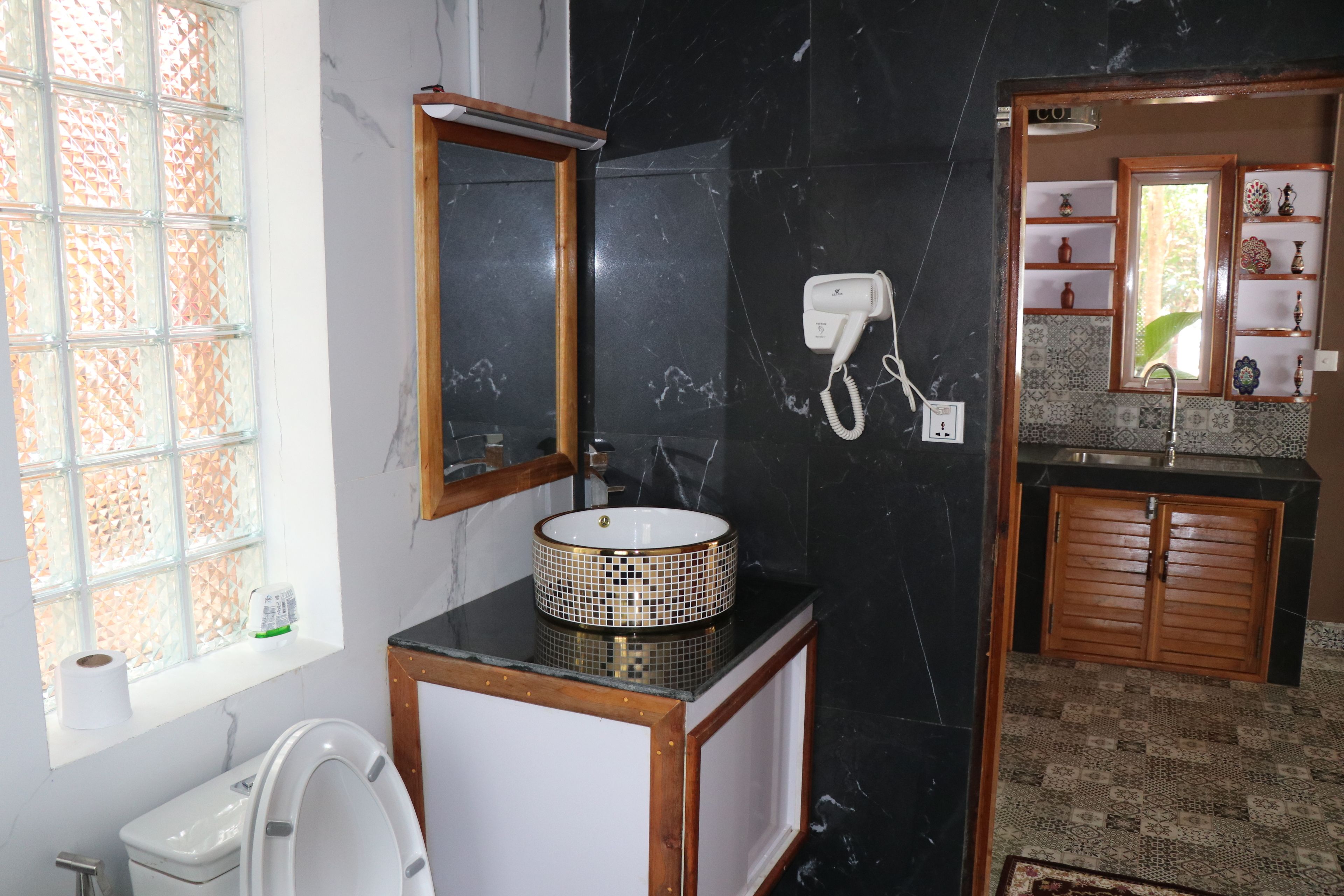 A bathroom with a toilet, sink, and mirror.