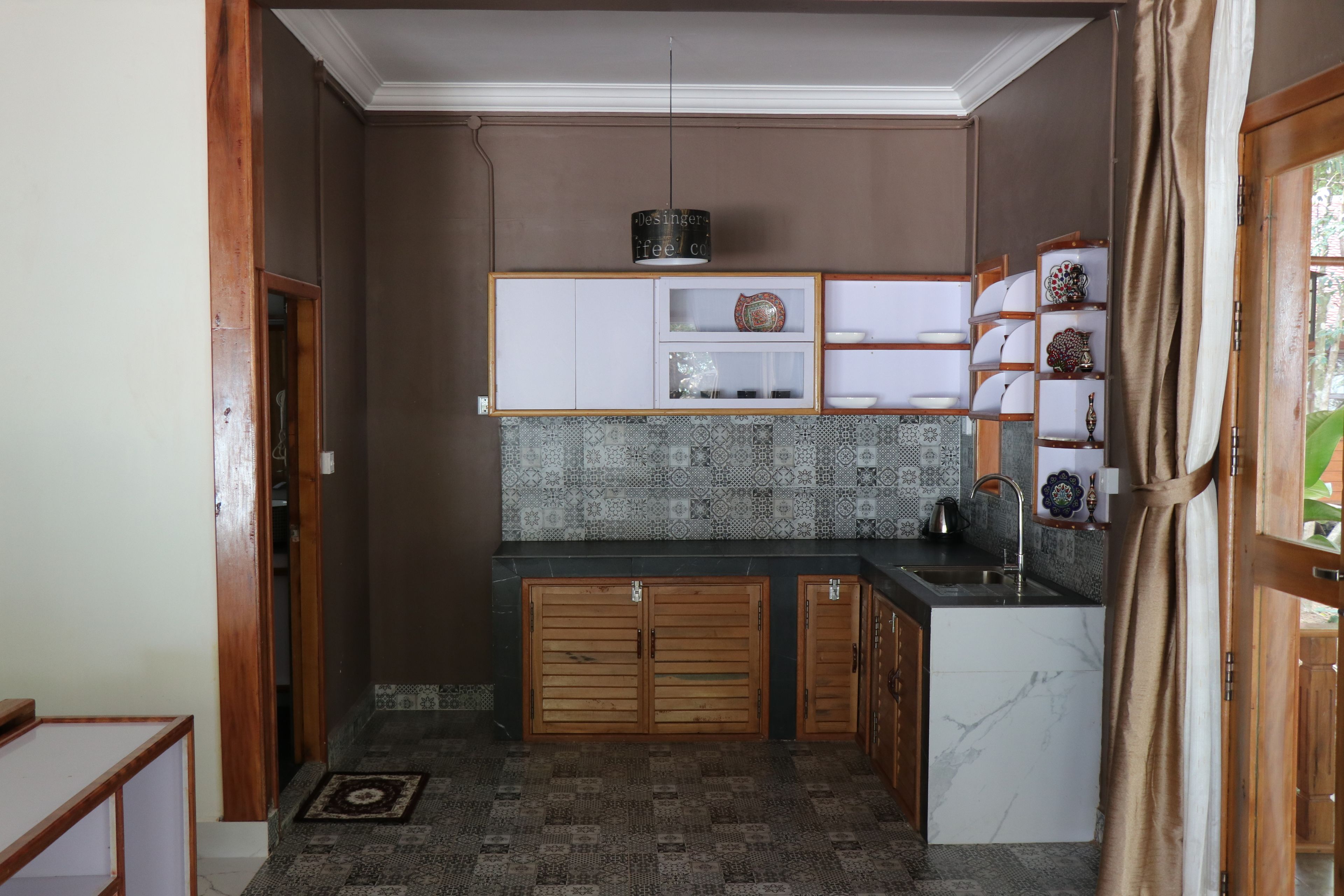 A compact kitchen with wooden cabinets, a built-in sink, and patterned backsplash tiles.