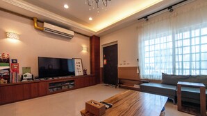 A spacious living area with a wooden coffee table, a flat-screen TV, and a sofa. - Tu Wei 192 (Zhuangwei)