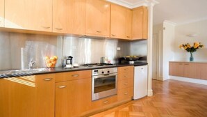 Una cocina moderna con armarios de madera, estufa a gas, horno y refrigerador.