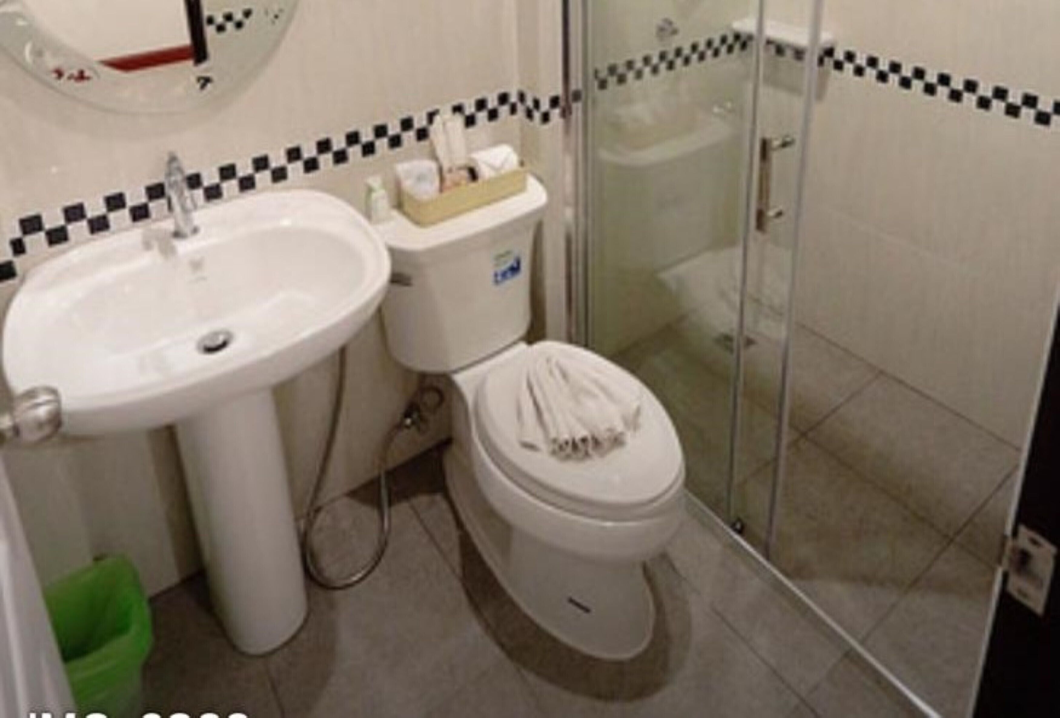 Un baño con lavamanos, inodoro y cabina de ducha de vidrio.
