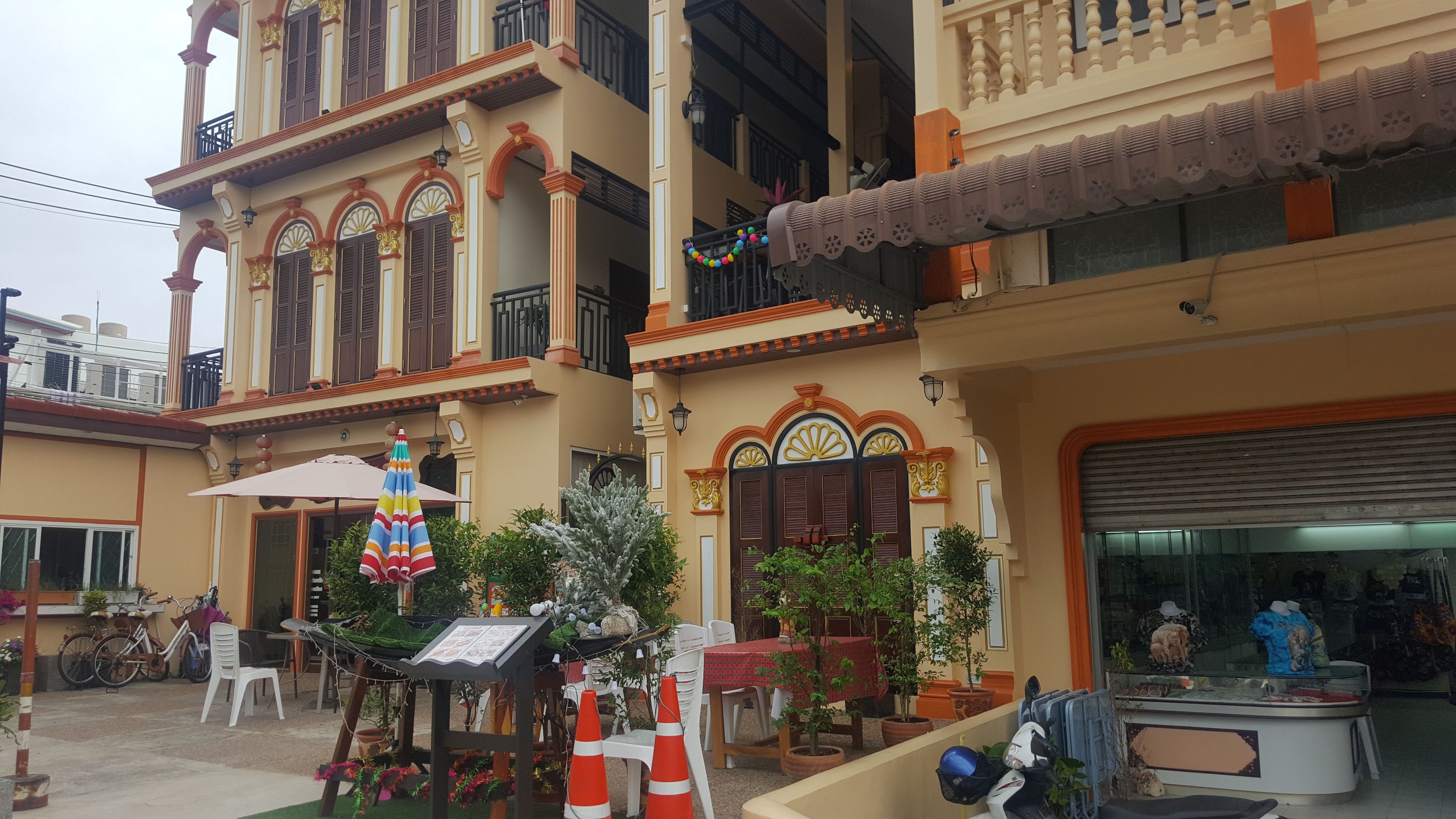 Un edificio tradicional con detalles arquitectónicos ornamentales, incluyendo ventanas de arco y molduras decorativas.