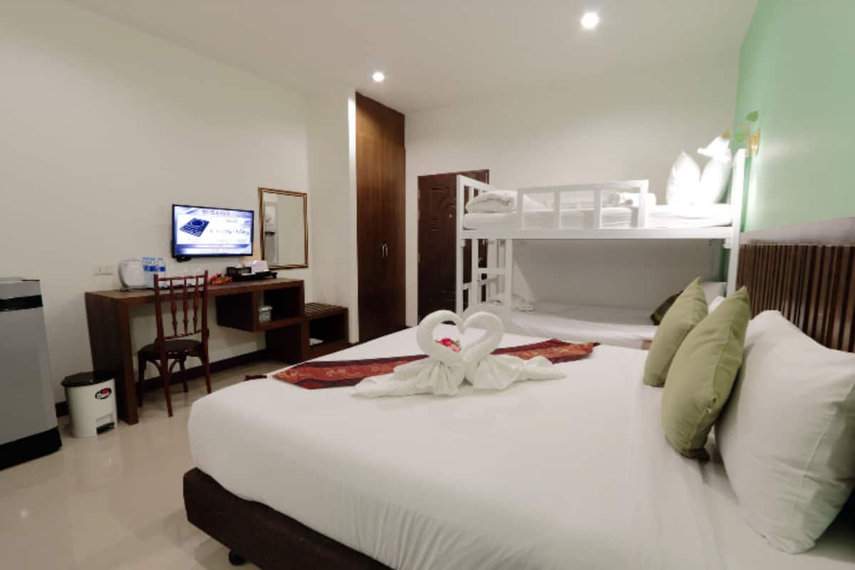 Une chambre d’hôtel comprenant un lit, un bureau, une chaise, une télévision et une armoire.