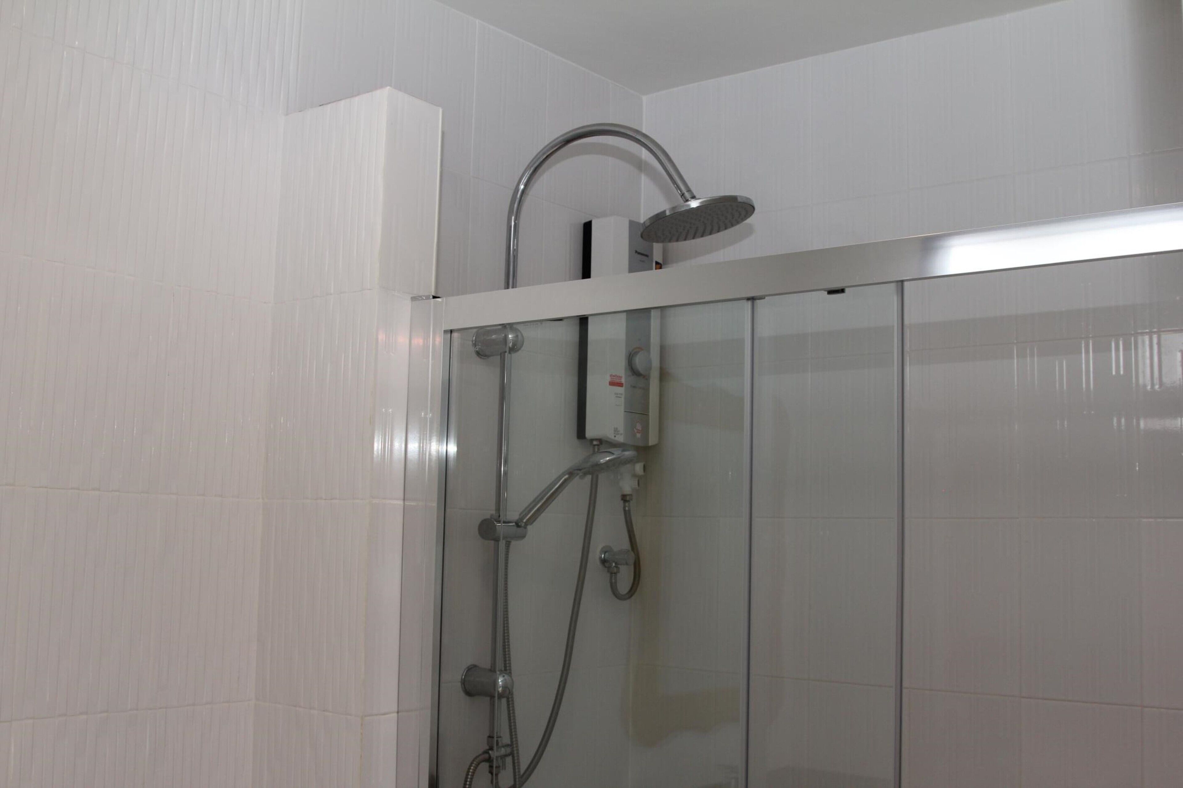 Una ducha moderna con cabezal de ducha de mano y grifo empotrado.