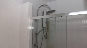 A modern shower with a handheld showerhead and a wall-mounted faucet.